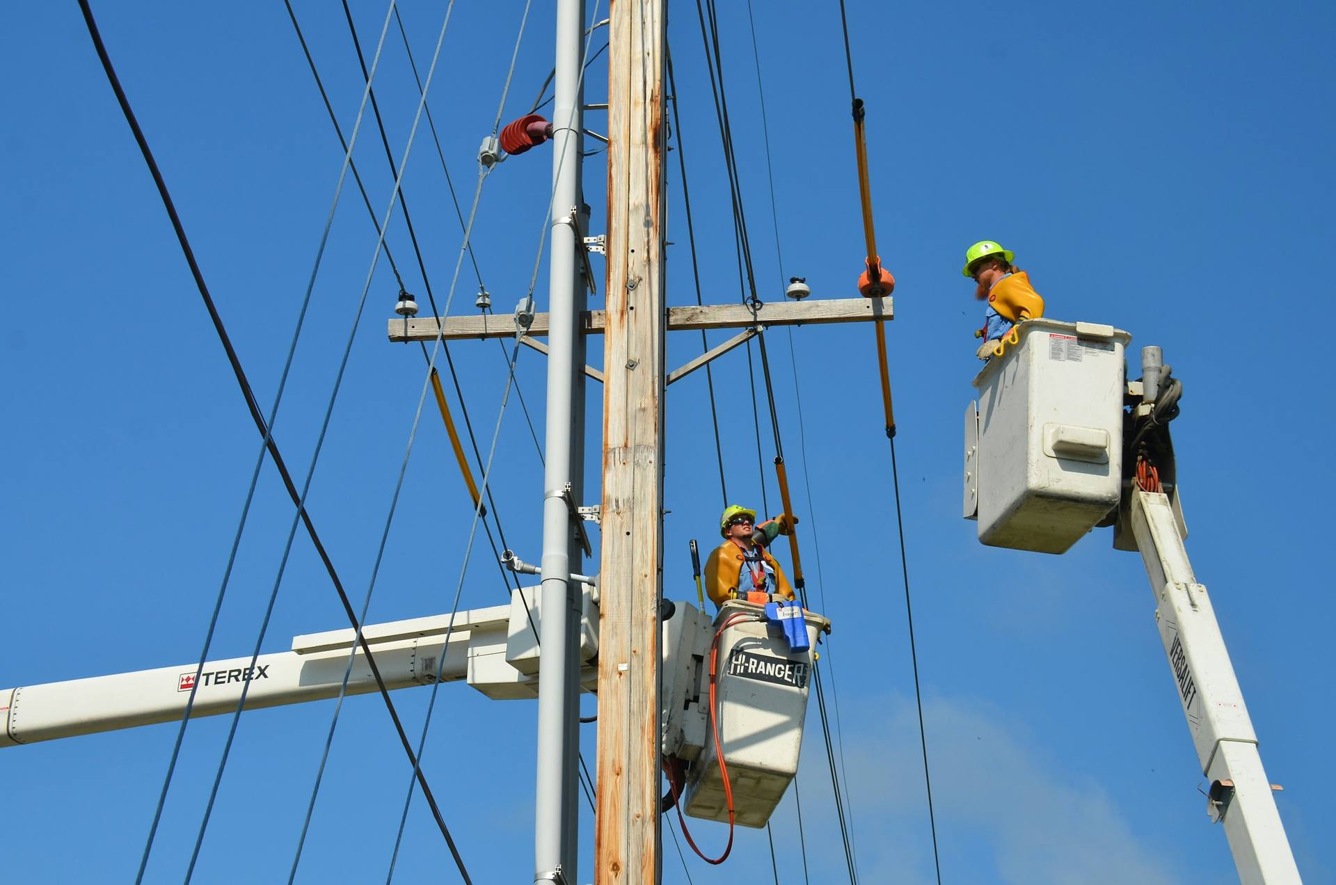 Line crew connecting a new service from bucket trucks